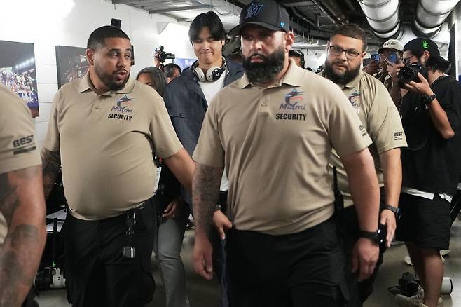 Japan's Shohei Ohtani, center, is escorted by security down a hallway Sunday, March 15, 2026, after Japan lost to Venezuela in a World Baseball Classic quarterfinal game in Miami. AP연합뉴스