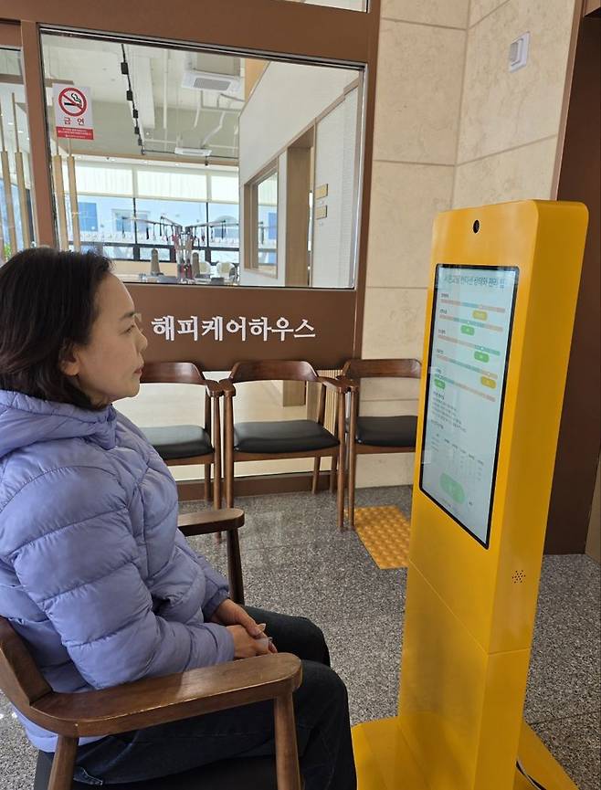 부산 남구 대연동 해피케어하우스 입구에 설치된 '키오스크 트리거 기반 다중 웨어러블 연동 케어 모니터링 시스템'을 이용하고 있는 모습. (주)해피케이365 제공