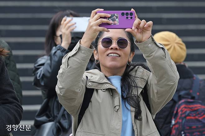 15일 서울 중구 세종문화회관 계단에 설치된 공연 홍보물 앞에서 관광객들이 사진을 찍고 있다.