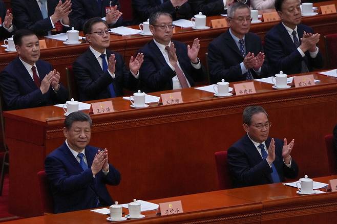 시진핑 중국 국가주석(맨 앞줄 왼쪽)과 리창 국무원 총리(앞줄 오른쪽)가 3월 4일 베이징 인민대회당에서 열린 전국인민정치협상회의(정협) 개막식에서 참석자들과 함께 박수 치고 있다. 리 총리는 3월 5일 전국인민대표대회(전국인대) 업무보고를 통해 올해 경제성장률 목표치, 예산안 등 주요 경제정책의 방향을 공개했다. AP 뉴시스