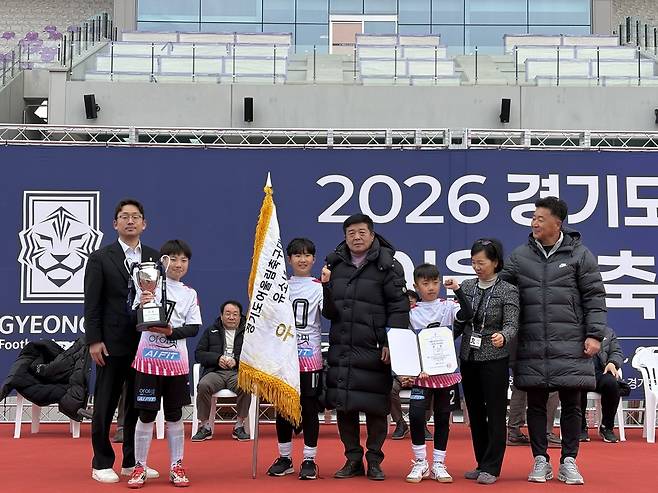 2026 경기도지사기 어울림 축구대회 유소년부에서 정상에 오른 하남시 선수단이 우승기를 들고 관계자들과 기념사진을 촬영하고 있다. <경기도축구협회 제공>
