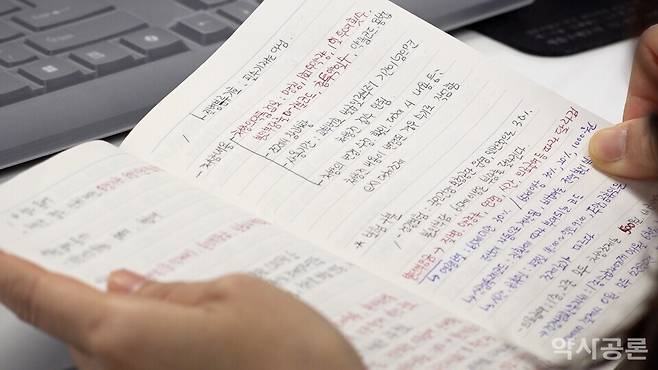 약국사무원 교육 프로그램 참가자가 필기시험 전 공부한 내용을 살펴보고 있다.