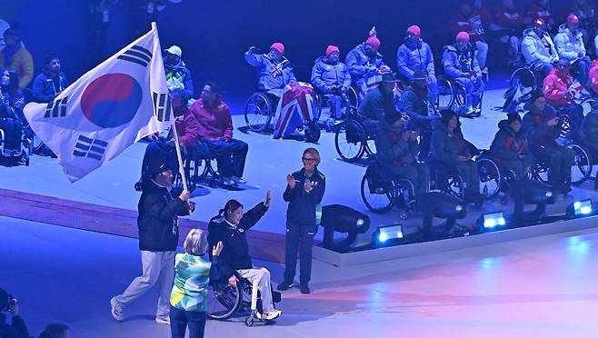 휠체어컬링 백혜진과 스노보드 이제혁이 5일(현지시간) 이탈리아 코르티나담페초 컬링 올림픽 스타디움에서 열린 2026 밀라노 코르티나 패럴림픽 폐막식에서 태극기를 들고 입장하고 있다. 2026.3.16 ⓒ 뉴스1 사진공동취재단