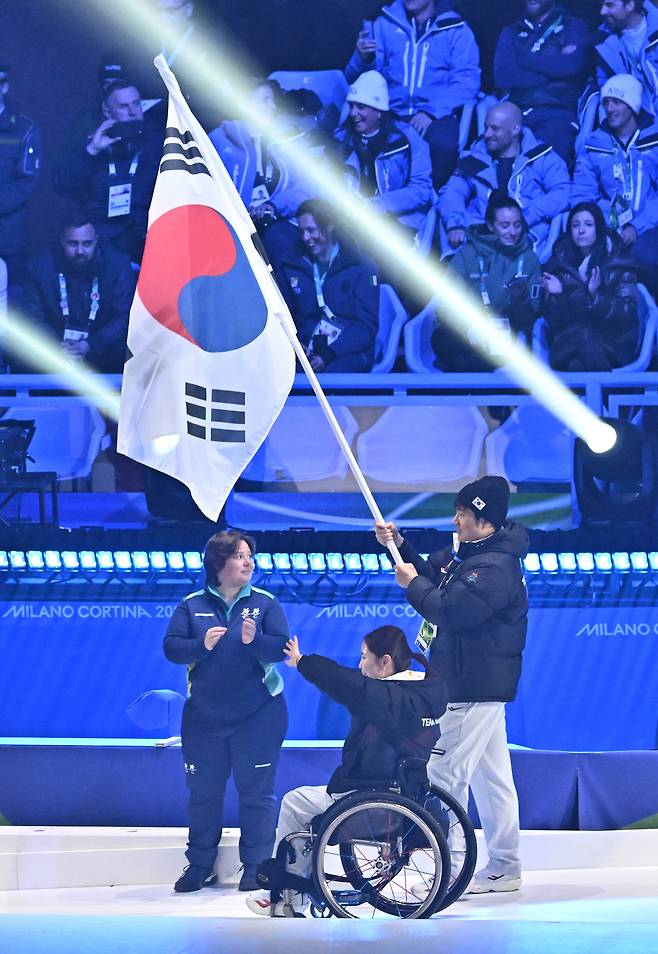휠체어컬링 백혜진과 스노보드 이제혁이 5일(현지시간) 이탈리아 코르티나담페초 컬링 올림픽 스타디움에서 열린 2026 밀라노 코르티나 패럴림픽 폐막식에서 태극기를 들고 입장하고 있다. 2026.3.16 ⓒ 뉴스1 사진공동취재단
