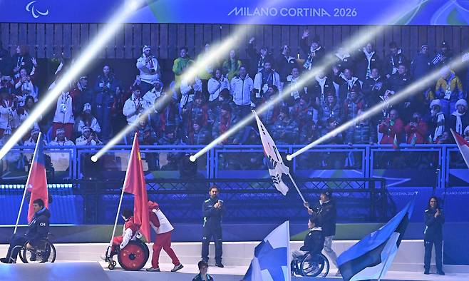 휠체어컬링 백혜진과 스노보드 이제혁이 5일(현지시간) 이탈리아 코르티나담페초 컬링 올림픽 스타디움에서 열린 2026 밀라노 코르티나 패럴림픽 폐막식에서 태극기를 들고 입장하고 있다. 2026.3.16 ⓒ 뉴스1 사진공동취재단
