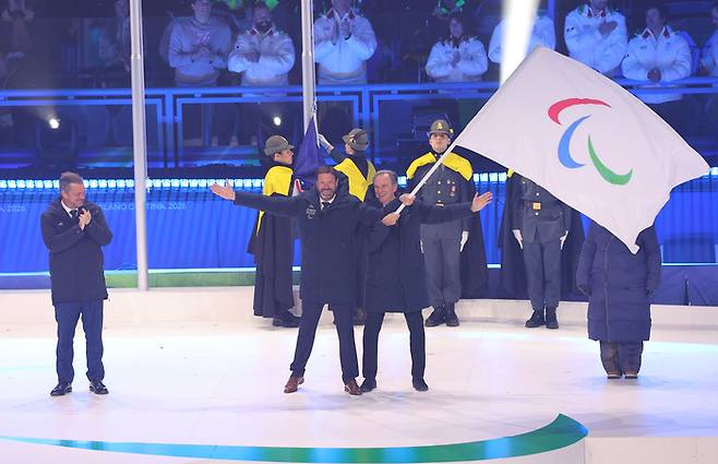 15일(현지시간) 이탈리아 코르티나 컬링 올림픽 스타디움에서 열린 2026 밀라노·코르티나 동계패럴림픽 폐막식에서 차기 개최국인 프랑스 관계자들이 패럴림픽 기를 흔들고 있다. 사진 | 코르티나=연합뉴스