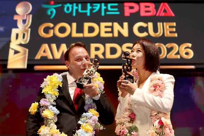 프로당구 PBA 남녀부 대상을 받은 다니엘 산체스(왼쪽)와 김가영이 대상 트로피에 입을 맞추고 있다. 사진=PBA