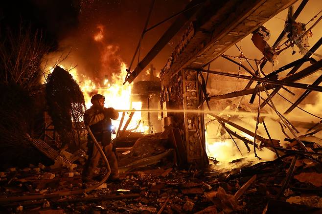 16일 우크라이나 자포리자에서 러시아의 드론 공격을 받아 화재가 발생한 민간인 가옥에서 한 소방관이 진화작업을 하고 있다. /AP 연합뉴스