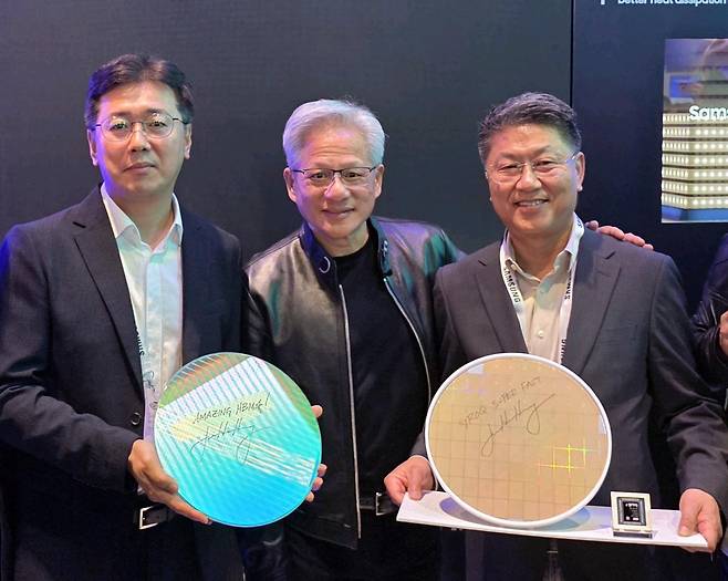 젠슨 황 엔디비아 CEO가 16일(현지 시간) 미국 새너제이에서 열린 엔비디아 GTC 2026 삼성전자 부스를 방문해 기념촬영 하고 있다. 왼쪽부터 황상준 삼성전자 메모리개발담당 부사장, 황 CEO, 한진만 삼성전자 파운드리 사업부장 사장. 제품은 왼쪽부터 삼성전자 HBM4 코어다이 웨이퍼와 그록(Groq) LPU 파운드리 4나노 웨이퍼. 각 웨이퍼에는 ‘AMAZING HBM4’와 ‘Groq Super FAST’라는 젠슨 황 CEO의 친필 서명이 적혀 있다. 사진=삼성전자 제공