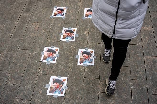 지난 15일(현지시간) 미국 뉴욕 메트로폴리탄 예술 박물관 밖에서 열린 시위 현장에 이란 최고 지도자 모즈타바 하메네이의 사진이 길 바닥에 붙여져있다.AP연합뉴스