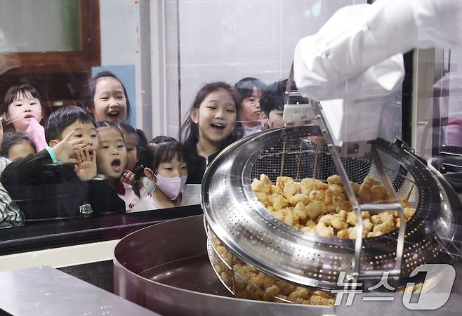 18일 경기 수원시 장안구 대평초등학교 내 위치한 거점형 학교급식 튀김 지원실에서 1학년 학생들이 튀김 조리 로봇이 직접 가동되는 현장을 보고 있다. 2026.3.18 ⓒ 뉴스1 김영운 기자