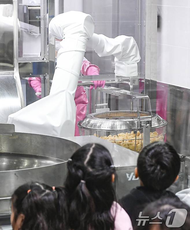 18일 경기 수원시 장안구 대평초등학교 내 위치한 거점형 학교급식 튀김 지원실에서 1학년 학생들이 튀김 조리 로봇이 직접 가동되는 현장을 보고 있다. (공동취재) 2026.3.18 ⓒ 뉴스1 김영운 기자