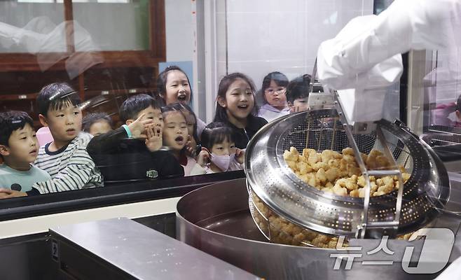 18일 경기 수원시 장안구 대평초등학교 내 위치한 거점형 학교급식 튀김 지원실에서 1학년 학생들이 튀김 조리 로봇이 직접 가동되는 현장을 보고 있다. 2026.3.18 ⓒ 뉴스1 김영운 기자