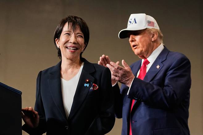 Japanese Prime Minister Sanae Takaichi (left), with US President Donald Trump, speaks to members of the military aboard the USS George Washington, an aircraft carrier docked at an American naval base in Yokosuka, Japan, Oct. 28, 2025. (AP)