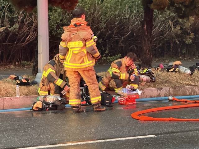 ▲ 20일 오후 6시30분쯤 대전 대덕구 문평동의 한 화재 현장에서 소방대원들이 연석에 걸터앉아 휴식을 취하고 있다./이용주기자