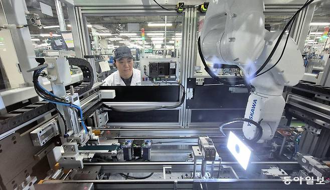 LS일렉트릭 충북 청주 공장에서 로봇 팔이 제품 불량을 검수하는 과정을 한 직원이 살펴보고 있다. 이 로봇은 생성형 인공지능(AI)을 활용해 수천 장의 불량 이미지를 학습해 정확도를 높였다. 청주=홍진환 기자 jean@donga.com