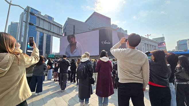 20일 신세계백화점 본점 외벽의 '신세계 스퀘어' 맞은편 인도에 인파가 몰려있다. 이곳에서는 정각마다 BTS의 신곡 뮤직비디오를 송출한다. 노유림 기자