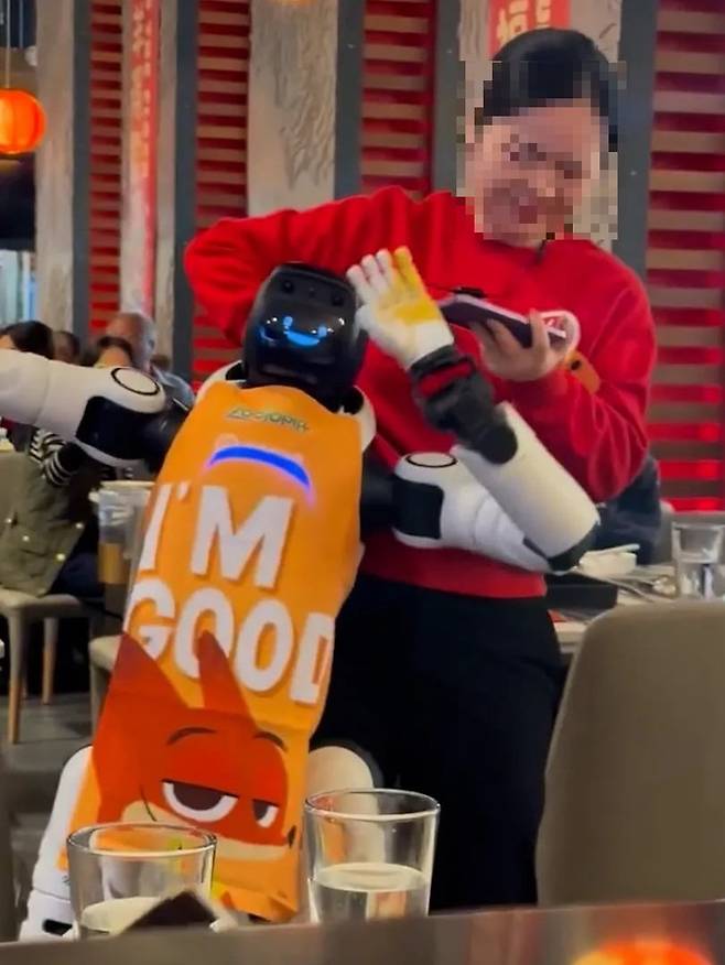 지난 주말 미국 캘리포니아주 쿠퍼티노 하이디라오 매장에서 직원이 춤추는 휴머노이드 로봇을 제지하고 있다. /사진=X 캡쳐