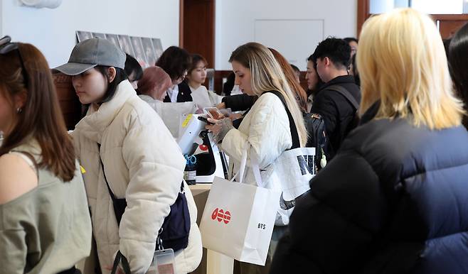 20일 서울 중구 신세계백화점 본점 헤리티지 뮤지엄에 마련된 ‘BTS POP-UP : ARIRANG’에서 아미(ARMY·팬덤명)들이 굿즈를 구입하고 있다. 신세계백화점은 하이브(HYBE)와 함께 방탄소년단(BTS) 완전체 컴백 분위기를 미리 체험할 수 있는 팝업스토어를 본점 더 헤리티지 4층에 마련했다. 뉴스1