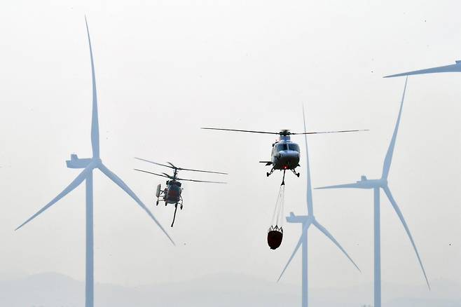 23일 오후 경북 영덕군 창포리 풍력발전단지 내 풍력발전기에서 발생한 불을 끄기 위해 산림청, 소방, 인근 지자체 헬기들이 진화작업을 벌이고 있다. 2026.3.23 (영덕=뉴스1)