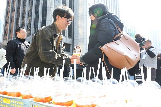 장항준 감독이 12일 서울 중구 한국프레스센터 광장에서 열린 영화 '왕과 사는 남자' 흥행 감사 커피차 이벤트에서 시민에게 커피를 전달하고 있다.