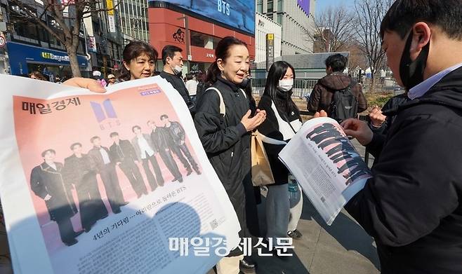 21일 서울 광화문광장에서 외국인 관광객들이 매일경제신문이 발행한 BTS 관련 특별판을 받고 있다. 사진|한주형 기자