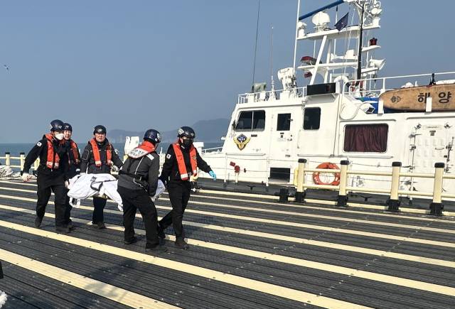경남 통영시 한산면 매물도 갯바위에서 홀로 낚시하다 실종된 70대 남성이 결국 주검으로 발견됐다. 통영해양경찰서 구조대가 발견된 시신을 옮기고 있다. 통영해양경찰서 제공