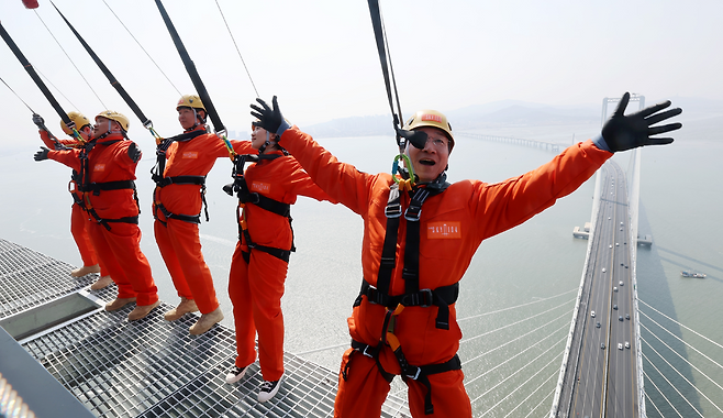 ▲ 25일 인천 서구 청라하늘대교(제3연륙교) 전망대에서 유정복 인천시장이 개장을 앞두고 진행된 시설 점검에 참석해 안전 장비를 착용한 채 외부 공간을 걷는 '엣지워크'를 체험하고 있다. /이재민 기자 leejm@incheonilbo.com