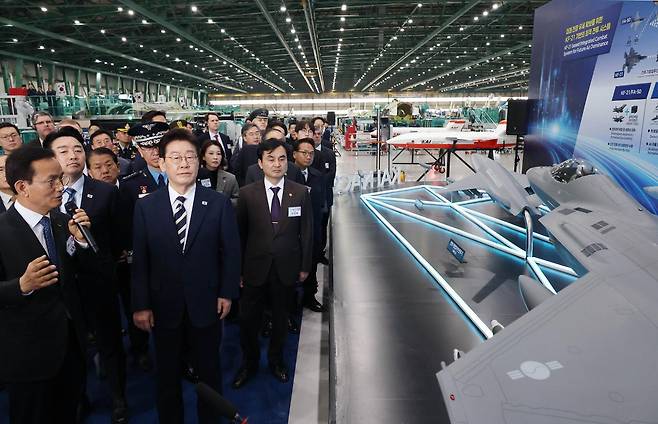 이재명 대통령이 25일 오후 경남 사천 한국항공우주산업(KAI)에서 KF-21 양산 1호기 출고식을 마친 뒤 관계자들과 생산 현장 시찰을 하고 있다. 20260324 청와대사진기자단