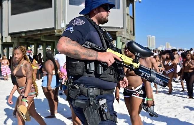 미국 플로리다 파나마시티비치 해변에서 경찰이 봄방학 시즌 인파를 순찰하고 있다. 당국은 총격과 소란 우려가 커지자 해변 통제와 주류 규제, 야간 폐쇄 등 단속 수위를 높였다. 크리스토퍼 오켄도