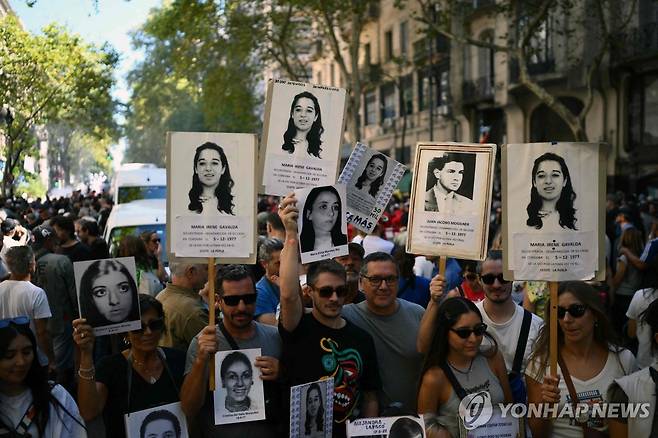 아르헨티나 군사 쿠데타 50주년 기념 행진 (부에노스아이레스=AFP 연합뉴스) 24일(현지시간) 아르헨티나 부에노스아이레스에서 마지막 군사 독재(1976-1983) 쿠데타 50주년을 맞아 마요 광장으로 행진하는 동안 시위자들이 실종된 사람들의 초상화를 들고 있다. 2026.3.25 photo@yna.co.kr