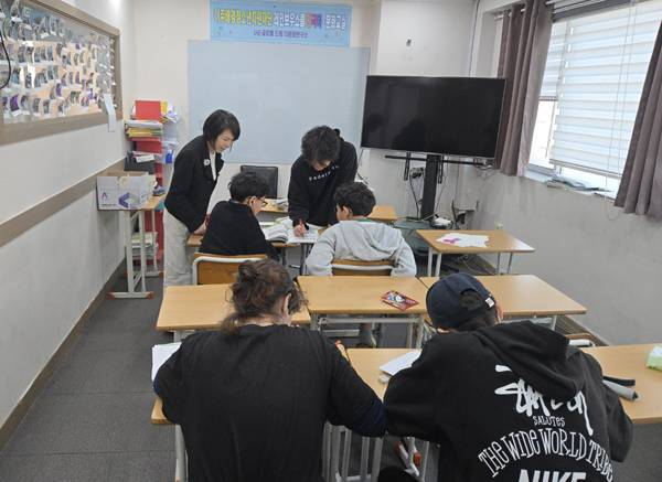 드미트리가 후배들에게 읽기를 가르치고 있다.