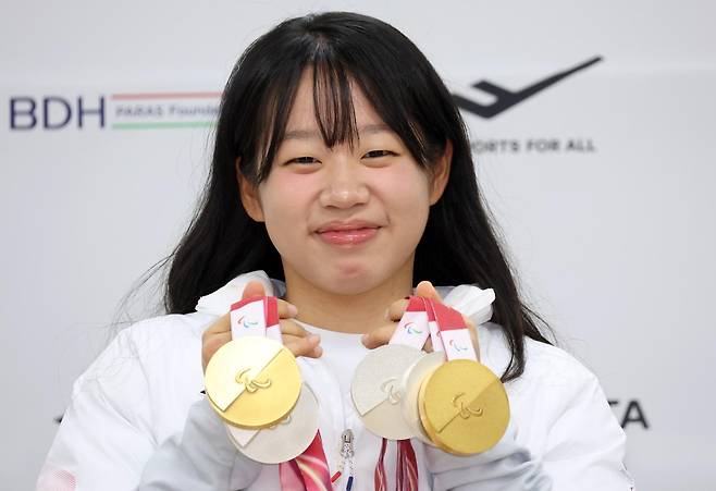 2026 밀라노-코르티나담페초 겨울패럴림픽 한국 선수단 최우수선수(MVP)로 뽑힌 김윤지가 26일 기자회견 도중 이번 대회에서 수확한 금메달 2개와 은메달 3개를 들어 보이며 밝게 웃고 있다. 대한장애인체육회 제공