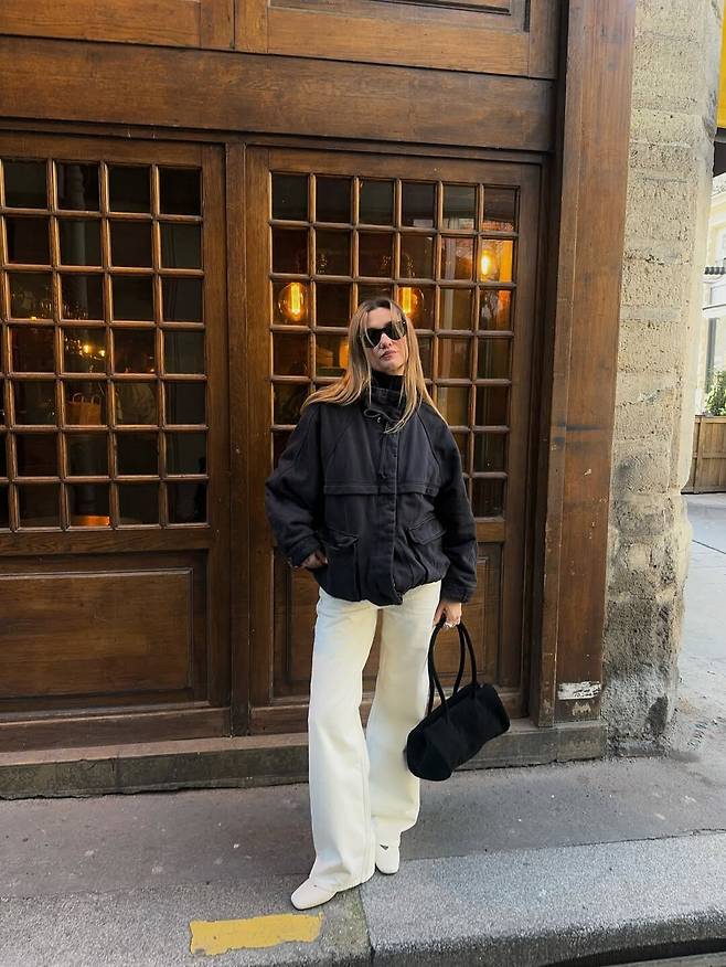 윈드 브레이커와 클래식 화이트 팬츠, 플랫 슈즈의 매치로 연출한 모노크롬 시크. @annelauremais