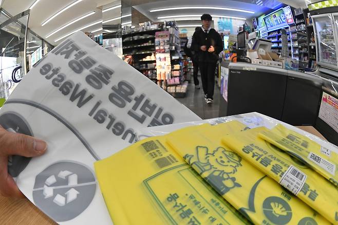 미국·이스라엘과 이란 간 전쟁 여파로 나프타 공급이 불안정한 가운데 종량제봉투 등 비닐류 품절 사례가 잇따르는 등 비닐 대란 우려가 확산하고 있다. 25일 서울 도심 내 편의점에서 한 시민이 종량제 봉투를 구매하고 있다. 임세준 기자