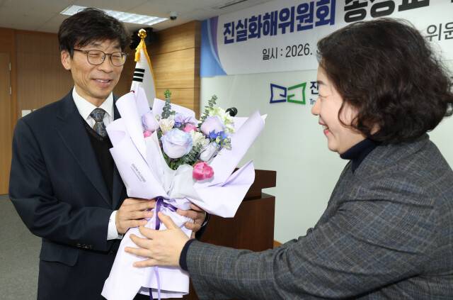 송상교 진실화해위원장이 4일 오후 서울 중구 퇴계로 진실화해위 6층 대회의실에서 열린 취임식에서 간부가 건네는 축하 꽃다발을 받고 있다. 김정효 기자 hyopd@hani.co.kr