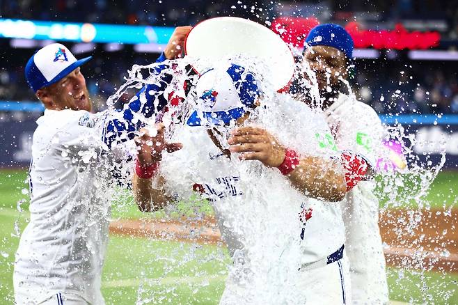 토론토 오카모토가 30일 애슬레틱스전에서 홈런을 날리며 승리한 뒤 동료들로부터 물세례를 받고 있다. AFP연합뉴스