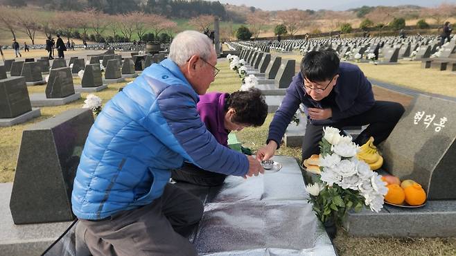 현덕홍씨 표지석에 참배하러 온 여동생 현정자(가운데)씨와 그의 남편, 현씨의 조카 현종훈(맨 오른쪽)씨 (사진, 신동원 기자)