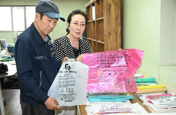 재활용품으로 종량제 봉투를 제작히는 창원시 마산합포구 진북면 인곡리 인테크. 이영상(왼쪽) 대표가 질김 정도를 보여주고 있다. /김구연 기자
