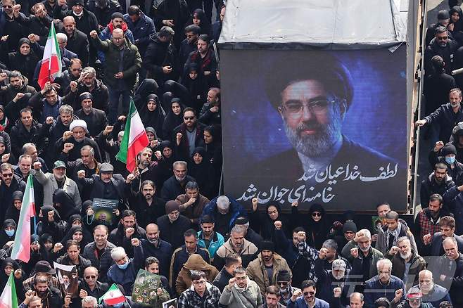 지난달 11일(현지시간) 이란 테헤란 엔겔라브 광장에서 열린 이란 혁명수비대(IRGC) 지휘관 등의 장례식에서 이란의 새 최고지도자 모즈타바 하메네이의 초상화가 화면에 표시되고 있다. 2026.03.12. ⓒ AFP=뉴스1