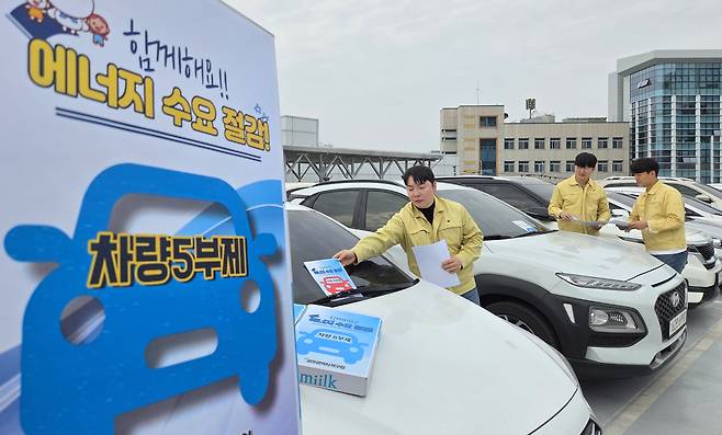 광주 북구 에너지정책팀 직원들이 구청 구차장에서 직원들 차량을 대상으로 5부제 참여를 독려하는 내용물을 차량에 부착하고 있다. /김영근 기자