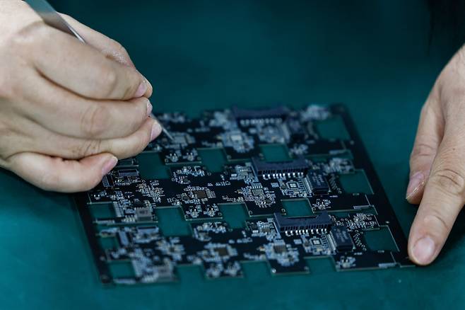 중국 광둥성 둥관의 한 공장에서 직원이 인쇄회로기판(PCB)을 작업하고 있다.(둥관(중국)/로이터연합뉴스)