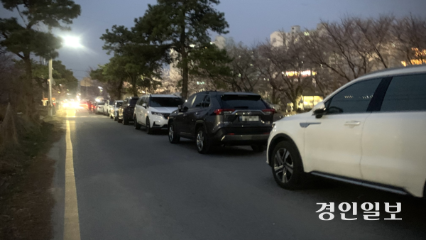 지난 4일 저녁 수원시 권선구 오목천동 황구지천 목장교 인근 하천변 길. 차량들이 길 한쪽을 따라 줄지어 불법 주차돼 있어 보행자 통행로가 크게 좁아진 모습이다. 2026.4.4 /유혜연기자 pi@kyeongin.com