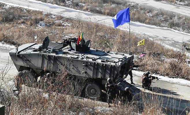 육군 보병들이 지난해 1월 경기 포천 승진훈련장에서 진행된 '공지합동 통합화련 운용 훈련'에서 K808 차륜형 장갑차에서 내려 목표고지를 점령하고 있다. 육군 제공