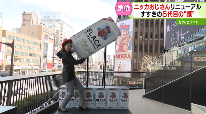 일본 STV방송 기자가 삿포로 시내 닛카상 간판 교체에 맞춰 설치된 포토 부스에서 닛카상에게 맥주를 따라주는 듯한 포즈를 취하고 있다. STV 동영상 캡처