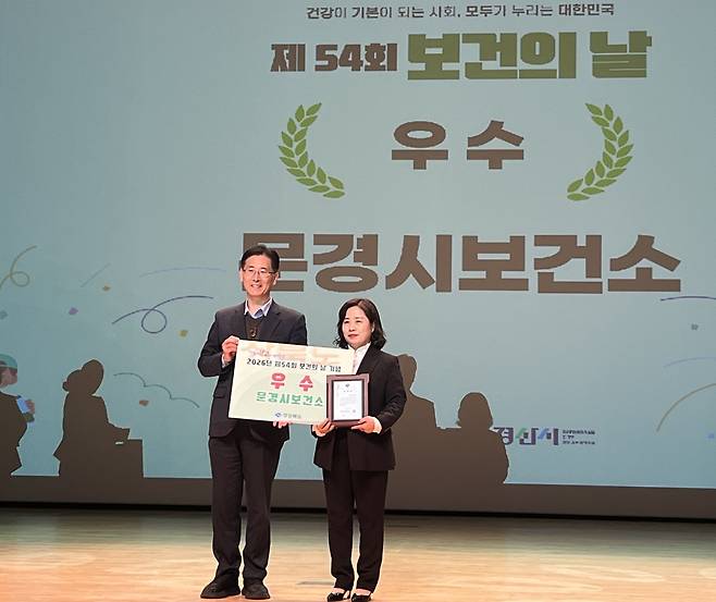 문경시보건소가 7일 경산시민회관 대강당에서 열린 ‘제54회 보건의 날’ 행사에서 우수기관으로 선정돼 권상명 소장(오른쪽)이 황명석 경상북도지사 권한대행으로부터 수상하는 모습. /문경시보건소 제공