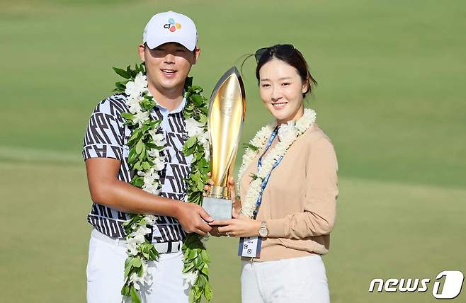 2023년 PGA투어 소니 오픈에서 우승한 뒤 아내 오지현과 함께 우승 트로피를 든 김시우. ⓒ AFP=뉴스1