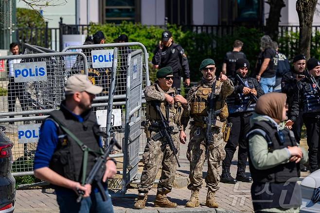 7일(현지시간) 튀르키예 이스탄불 주재 이스라엘 영사관 인근에서 경찰과 총격전이 벌어진 뒤 한 경찰관이 경계 태세를 유지하며 손짓하고 있다. 2026.04.07. ⓒ AFP=뉴스1