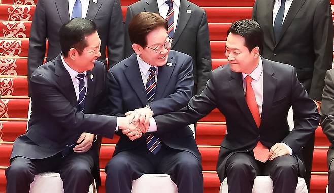 이재명 대통령(가운데)이 7일 청와대에서 여야정 민생경제 협의체 회담에 앞서 기념촬영 중 정청래 더불어민주당 대표(왼쪽), 장동혁 국민의힘 대표와 손을 잡고 있다. 청와대사진기자단