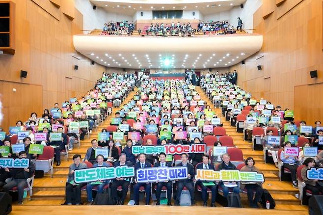 지난달 순천시 문화건강센터에서 열린 ‘RE100 반도체 국가산단과 기업 유치 시민 포럼’에서 노관규(앞줄 가운데) 순천시장을 비롯한 참석자들이 팻말을 든 채 기념촬영을 하고 있다. 순천시 제공